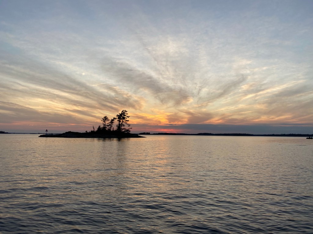 Sunset with streaming clouds on a lake looking at an island.